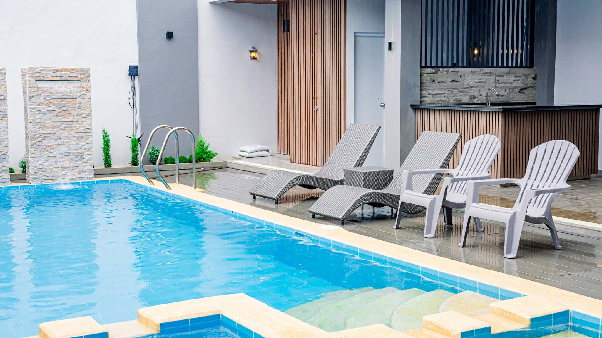 Poolside loungers and outdoor kitchen area