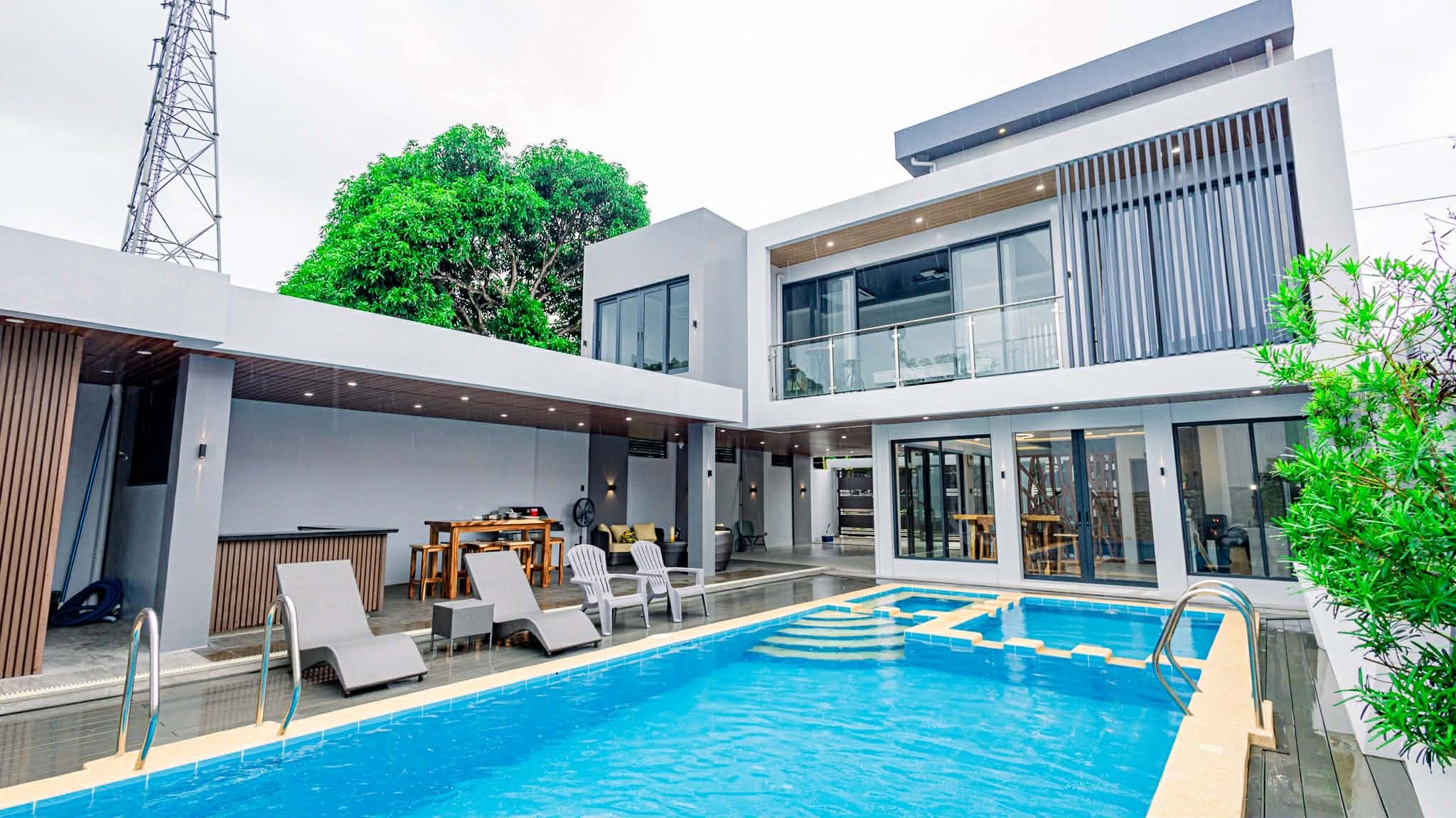 La Casa de Miguel private resort pool with modern villa, lounge chairs, and covered dining area